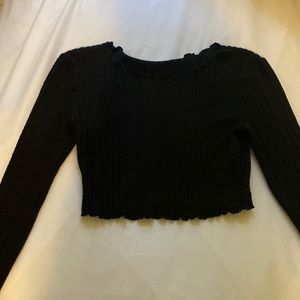 A small black long sleeve crop top.